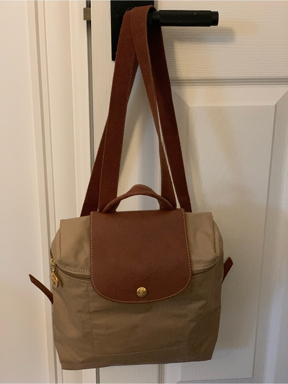 Longchamp backpack in olive green nylon. Brown leather flap with snap closure